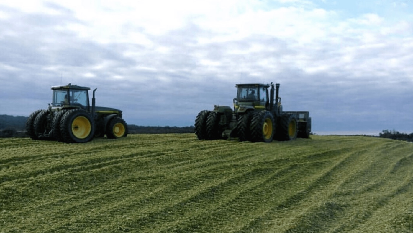 Dos tractores pisando un silo de maíz